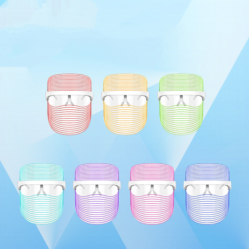 "Seven LED beauty masks in red, yellow, green, blue, transparent blue, purple and dark purple displayed on a gradient blue background"
