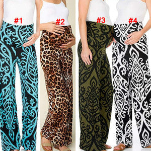 Woman wearing wide-leg maternity pants with high-waist elastic band, available in printed styles.