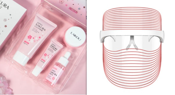 "Red light therapy mask displayed beside pink skincare kit with facial creams, serum and toner on a soft background"