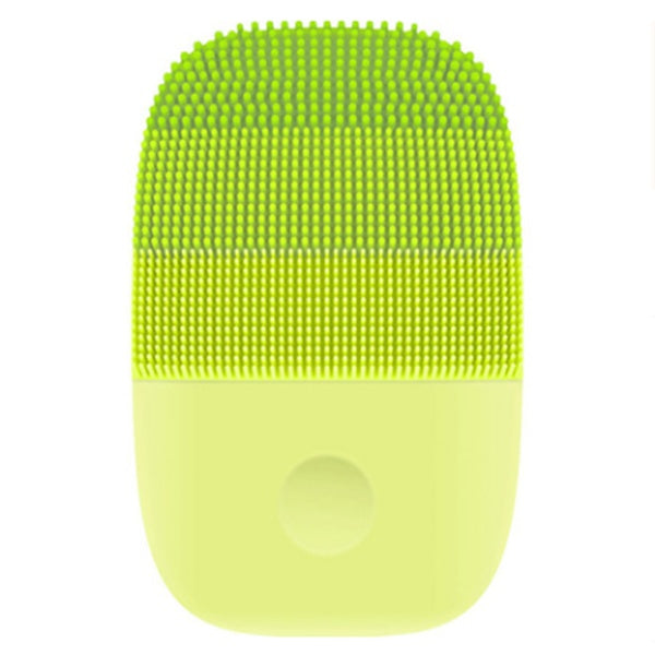Green travel-size facial cleansing brush with soft silicone bristles – ultrasonic skin care.