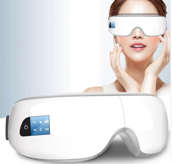 Woman wearing a white Bluetooth eye massager with digital display, shown touching her face gently. Below, close-up of the foldable device featuring power and music icons – ideal for heat therapy, vibration massage, and visual relaxation.