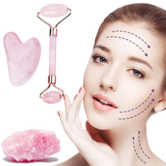 Woman using a pink rose quartz facial roller on her cheek and neck, with massage direction arrows indicating lifting motion. Gua Sha tool and crystal displayed beside the face on a white background.