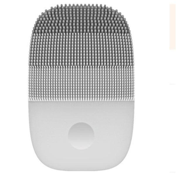 Grey silicone ultrasonic facial cleanser with curved shape – compact, travel-friendly and waterproof.