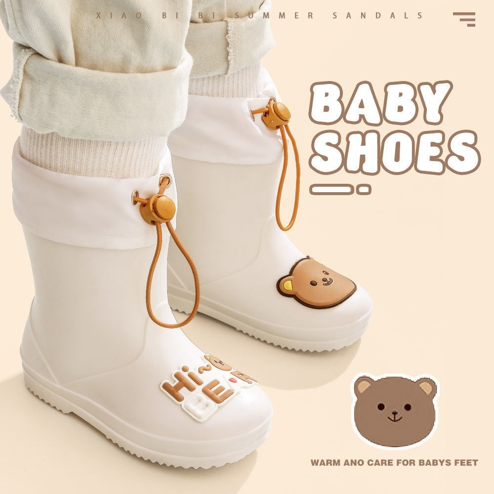 “White baby rain boots with teddy bear face, ‘Hi Bear’ lettering and drawstring elastic top – waterproof and non-slip PVC sole”

