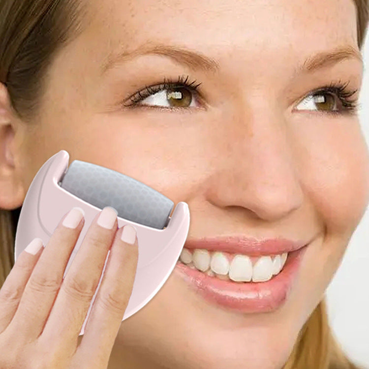 Pink heart-shaped ice roller for face massage and puffiness reduction – shown used on cheek with arrows indicating lifting effect