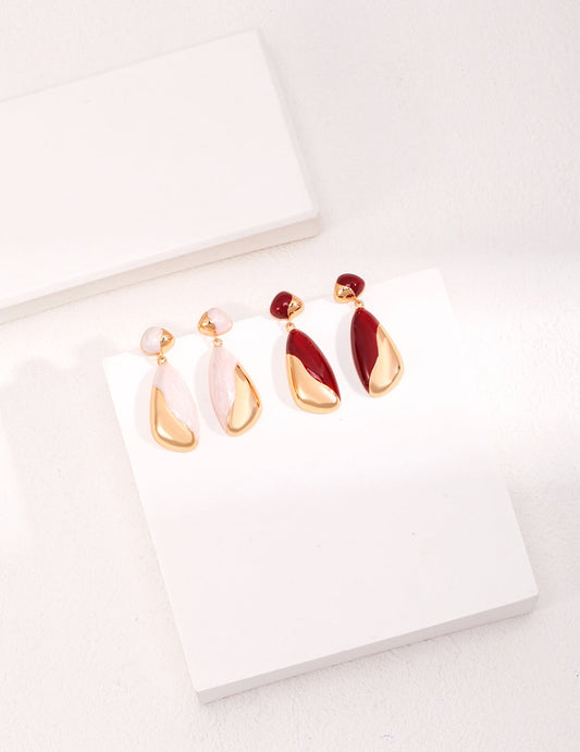 "A set of minimalist drip glaze earrings in soft pink, white, and deep red tones with 18ct gold vermeil teardrop accents, arranged on a clean white display.