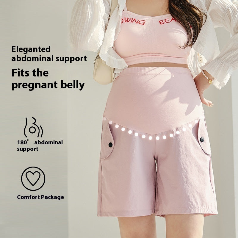 Maternity model wearing high-waist pink shorts with belly support