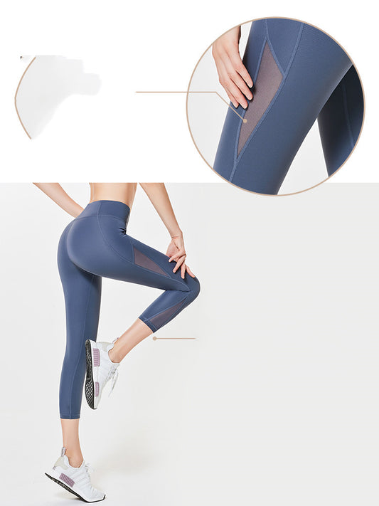 Model wearing stone blue cropped leggings with breathable mesh panels on the side, standing in profile pose.